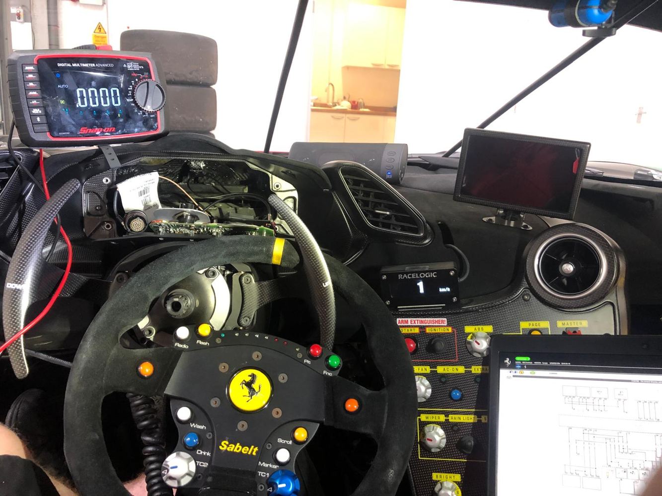 Race car cockpit diagnostics and electronics work.